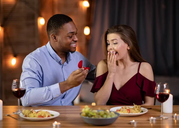 Proposta de casamento. romântico preto namorado propondo namorada para se casar com ele no restaurante — Fotografia de Stock