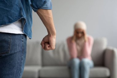 Kızgın adam, korkmuş ya da korkmuş kadın yüzünden yumruğunu cezalandırıyor.