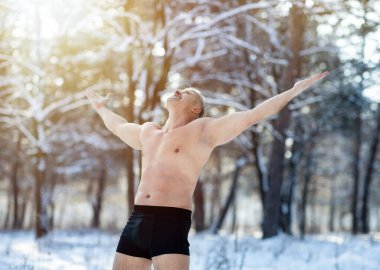 Happy mature man holding his arms out, standing in underwear in winter frost. Seasonal activities clipart
