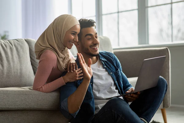 Amare coppia mediorientale utilizzando il computer portatile, avendo partito online — Foto Stock