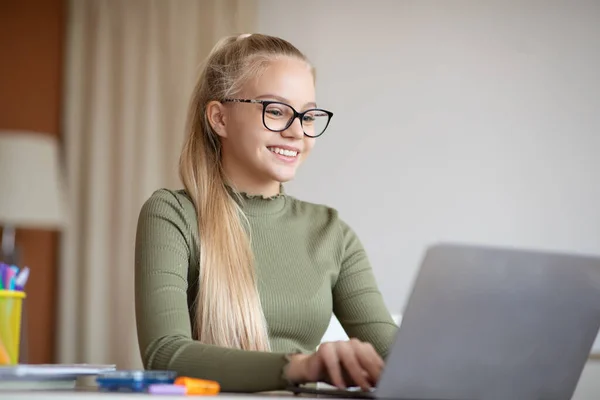 Sorrindo menina adolescente sentado em casa e usando laptop — Fotografia de Stock