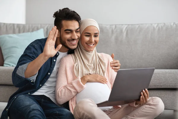 Ευτυχισμένο έγκυο μουσουλμάνα ζευγάρι κάνει βιντεοκλήση με φορητό υπολογιστή στο σπίτι — Φωτογραφία Αρχείου