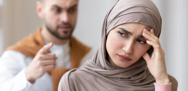 Wütender arabischer Ehemann bedroht frustrierte Ehefrau, die zu Hause steht, Panorama — Stockfoto