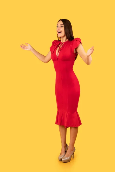 Έκπληκτη κυρία με το κόκκινο φόρεμα Posing σε κίτρινο φόντο, κάθετη — Φωτογραφία Αρχείου