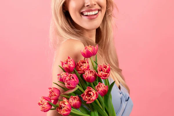 Vista ritagliata di giovane signora con bouquet di bei tulipani su sfondo rosa studio, primo piano — Foto Stock