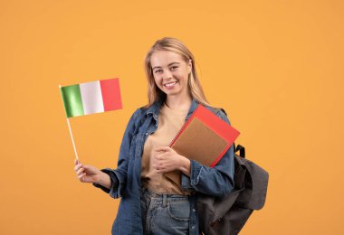 Not defterleri, sırt çantaları ve küçük bayrağıyla gülümseyen kadın üniversiteye gidiyor.