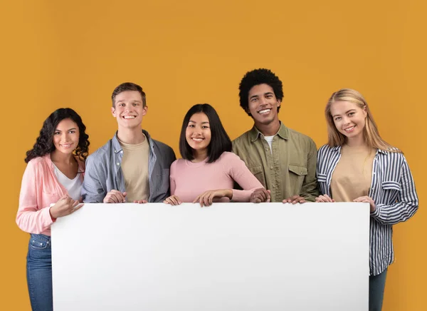 Diverse tieners vrolijke internationale studenten houden grote banner met vrije ruimte en klaar om te studeren — Stockfoto