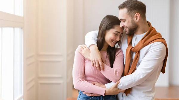 Pareja joven enamorada abrazándose de pie en casa, Panorama — Foto de Stock