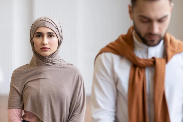 Muslim ehefrau im hijab standing hinter ehemann drinnen — Stockfoto