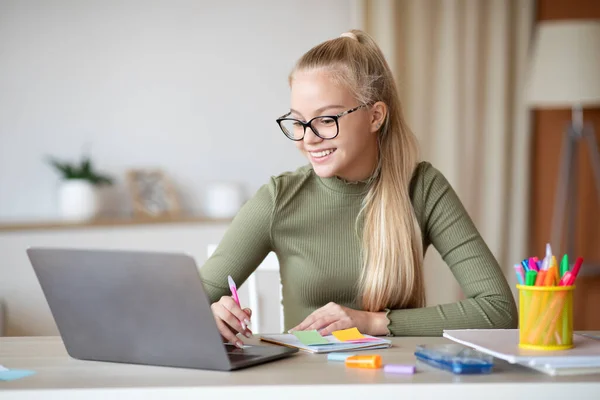 Roztomilé teen dívka s poznámkami a pomocí notebooku — Stock fotografie