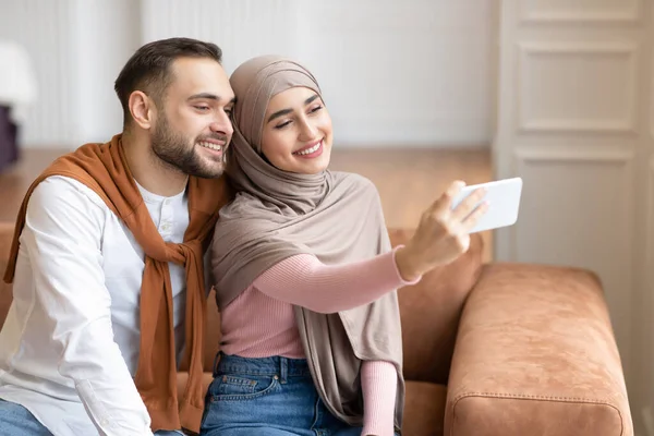 Casal árabe fazendo selfie no telefone se divertindo em casa — Fotografia de Stock