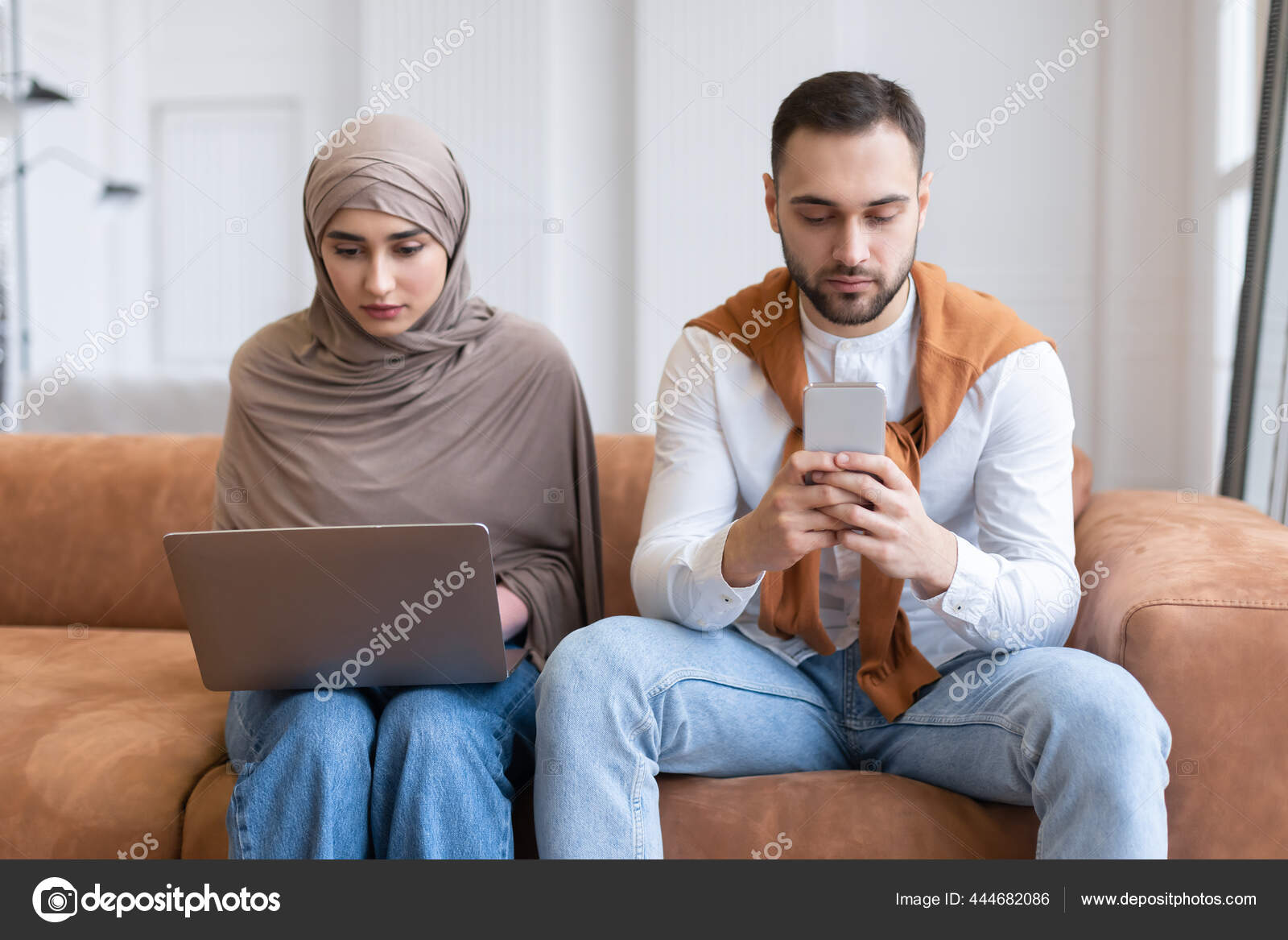 Мусульманские Супруги Сидят Дома С Ноутбуком И Мобильным Телефоном.