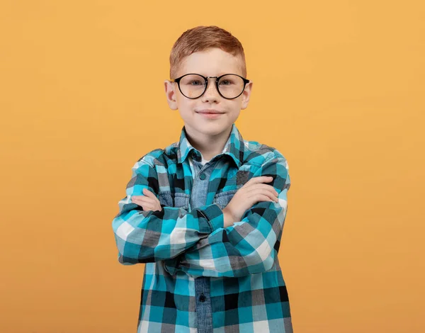 Niño jengibre inteligente en gafas posando en amarillo — Foto de Stock