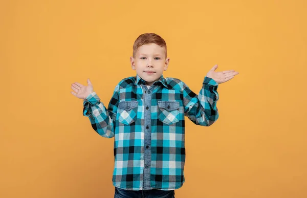 Chico de escuela desconcertado mostrando confusión, fondo amarillo — Foto de Stock