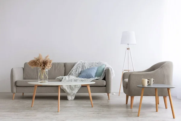 Sofá con almohadas azules y manta mullida, sillón vintage en suelo de madera — Foto de Stock