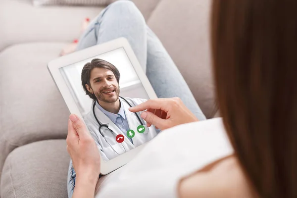 Femme avec tablette numérique ayant appel vidéo en ligne avec son médecin — Photo