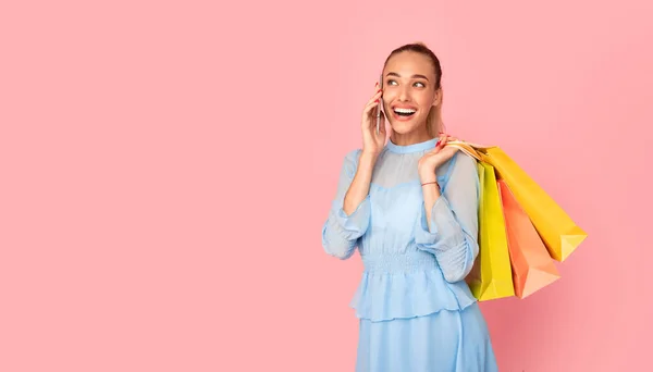 Sonriente dama hablando por teléfono sosteniendo bolsas de compras — Foto de Stock