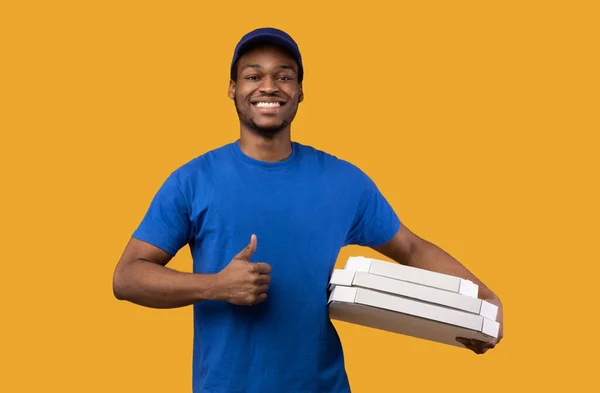 Repartidor negro sosteniendo cajas de pizza, mostrando los pulgares hacia arriba — Foto de Stock