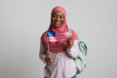 Amerikan bayrağı gösteren tesettürlü pozitif siyahi kadın