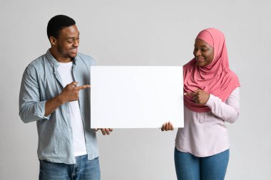 İlgilenen siyah çift boş pankartı işaret ediyor.