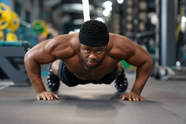 Muscular Africano atleta americano formação no chão no ginásio — Fotografia de Stock