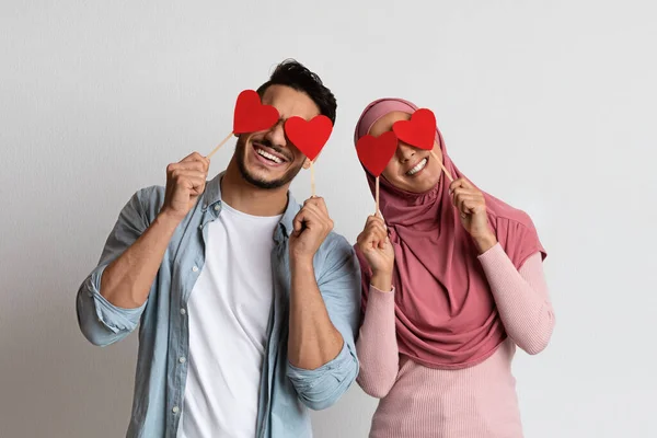 Valentines Fun. homme musulman joyeux et femme couvrant les yeux avec des coeurs rouges — Photo