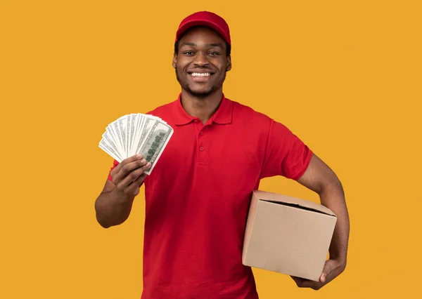 Repartidor negro sosteniendo dinero y caja — Foto de Stock