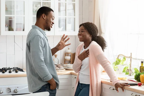 Alegre pareja negra pasar tiempo en cocina juntos, charlando y riendo — Foto de Stock