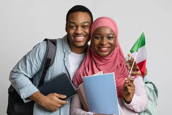 Closeup of black muslim students couple holding italian flag
