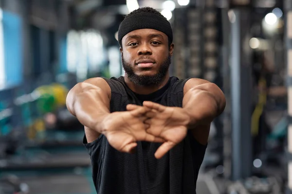 Sportsman stretching his hands before workout training at gym — Stock Photo, Image