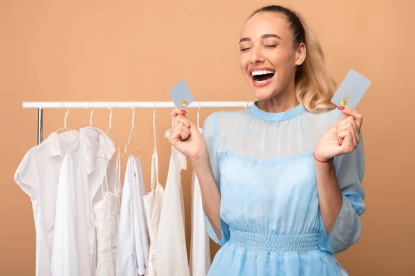 Happy stylish lady holding credit cards in both hands — Stock Photo, Image