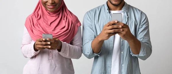 Beskärs av beroende svart par med mobiltelefoner — Stockfoto