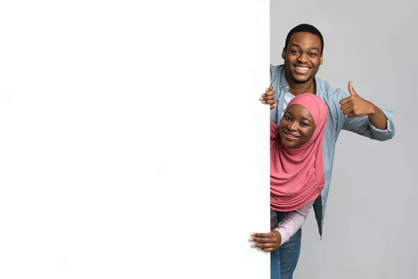 Positivo Africano americano muçulmano casal com placa vazia — Fotografia de Stock