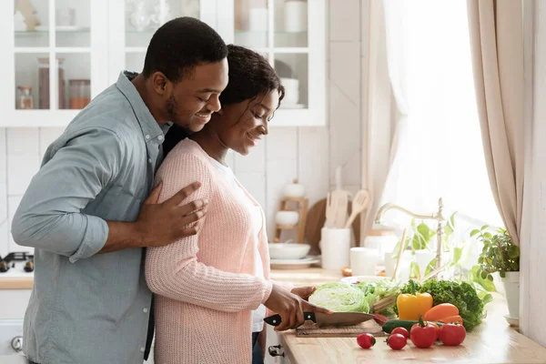 Amar a los cónyuges afroamericanos preparando comida saludable juntos en la cocina en casa — Foto de Stock