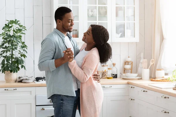 Couple romantique à la maison. Aimer les conjoints afro-américains dansant dans la cuisine intérieure — Photo