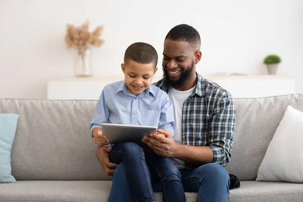 Αφροαμερικανός πατέρας και γιος χρησιμοποιώντας Tablet μαζί στο σπίτι — Φωτογραφία Αρχείου