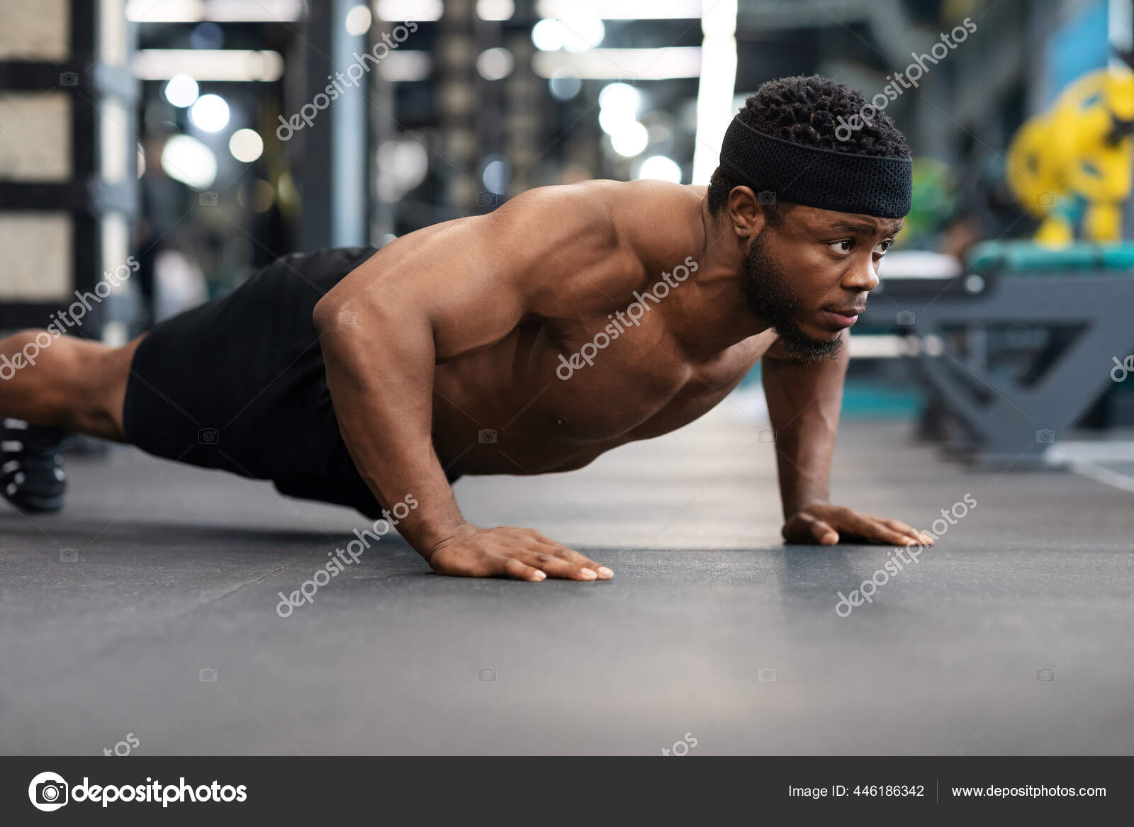 Shirtless black man making push ups on floor in gym Stock Photo by