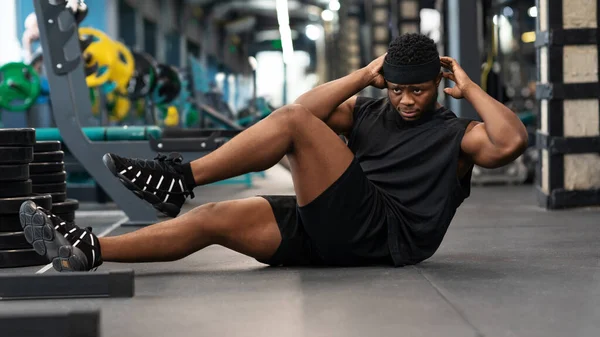 Black guy sportsman doing abs on floor in gym — Stock Photo, Image