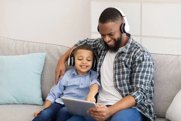 Padre e figlio nero che utilizzano il computer tablet digitale a casa — Foto Stock