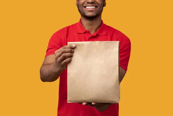 Glücklich lächelnder schwarzer Zusteller mit Paket — Stockfoto