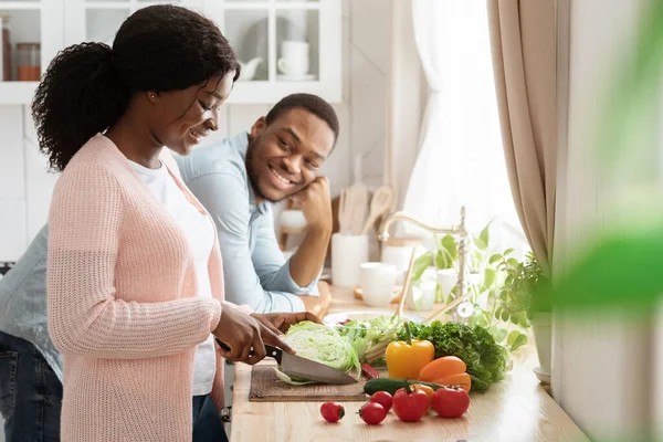 Χαμογελώντας μαύρο ζευγάρι μαγείρεμα στην κουζίνα μαζί, την προετοιμασία υγιεινό φυτικό γεύμα — Φωτογραφία Αρχείου