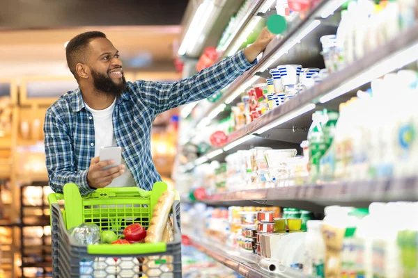 棚から製品を取るスーパーマーケットで黒男性ショッピング食料品 — ストック写真