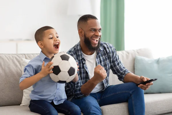 Africano padre e figlio guardare sport su tv a casa — Foto Stock