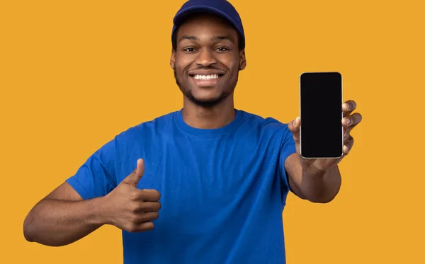 Hombre de entrega negro sosteniendo teléfono inteligente con pantalla en blanco para maqueta — Foto de Stock