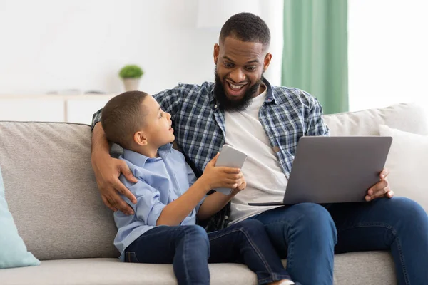 Padre e figlio utilizzando gadget, smartphone e tablet a casa — Foto Stock