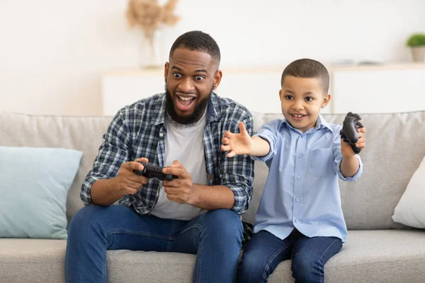 Africano padre y hijo tener divertido jugando video juego interior — Foto de Stock