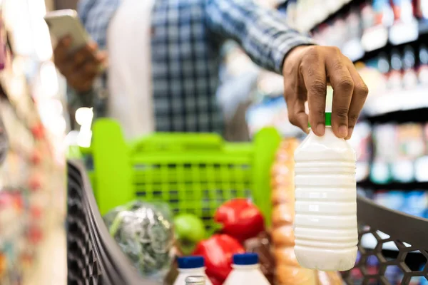 Guy Doing Grocery Shopping Putting Products In Cart In Supermarket