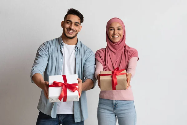 Šťastný arabský muž a žena v hidžábu ukazuje dárkové krabice na kameru — Stock fotografie
