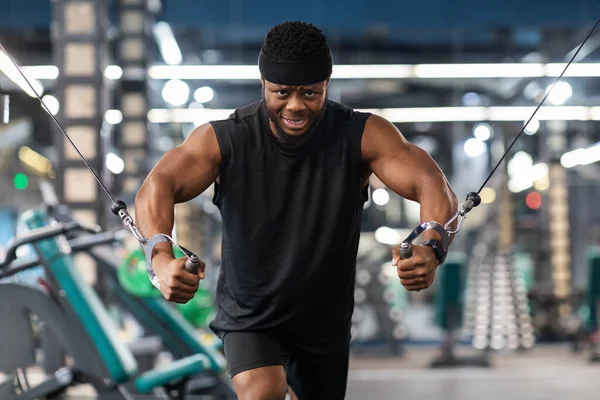 Motivated black sportsman having workout on crossover machine — Stock Photo, Image