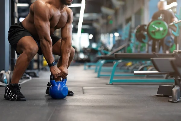 Cortado de homem muscular preto trabalhando com kettlebell — Fotografia de Stock